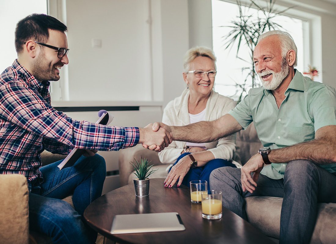 About Our Agency - Happy Older Couple Meet and Shake Hands With an Insurance Agent During a Casual Meeting