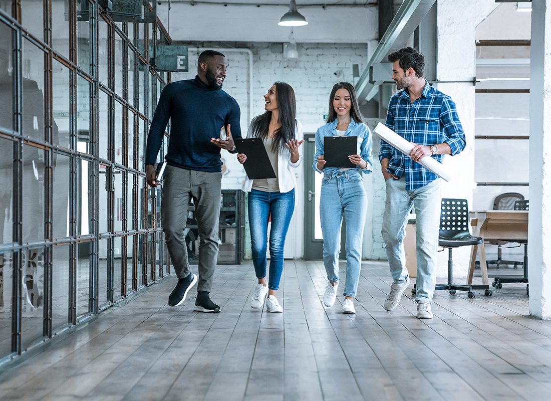 About Our Agency - Group of Young Professionals Walking Together and Talking in an Office