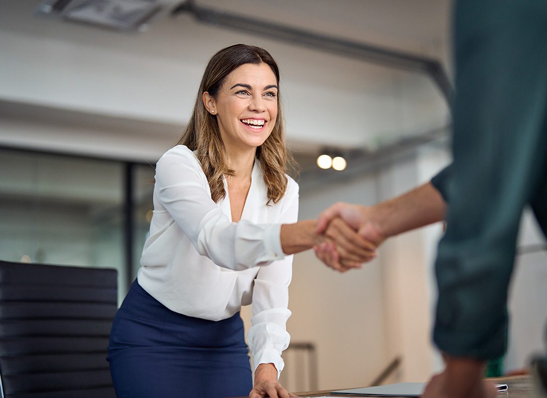 Join Our Team - Portrait of a Middle Aged Business Woman Shaking Hands with a Man During an Interview in the Office